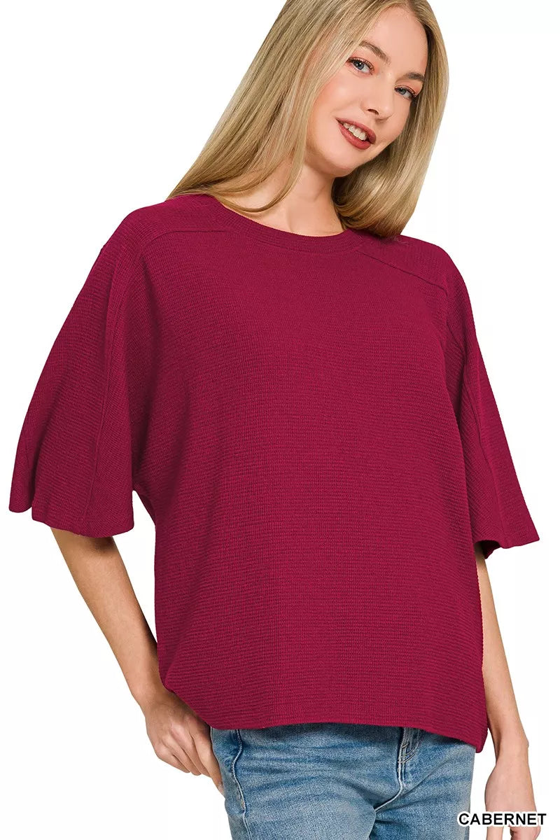 A woman wears a cabernet-colored, double-knit short-sleeve top with a relaxed fit and crew neck.